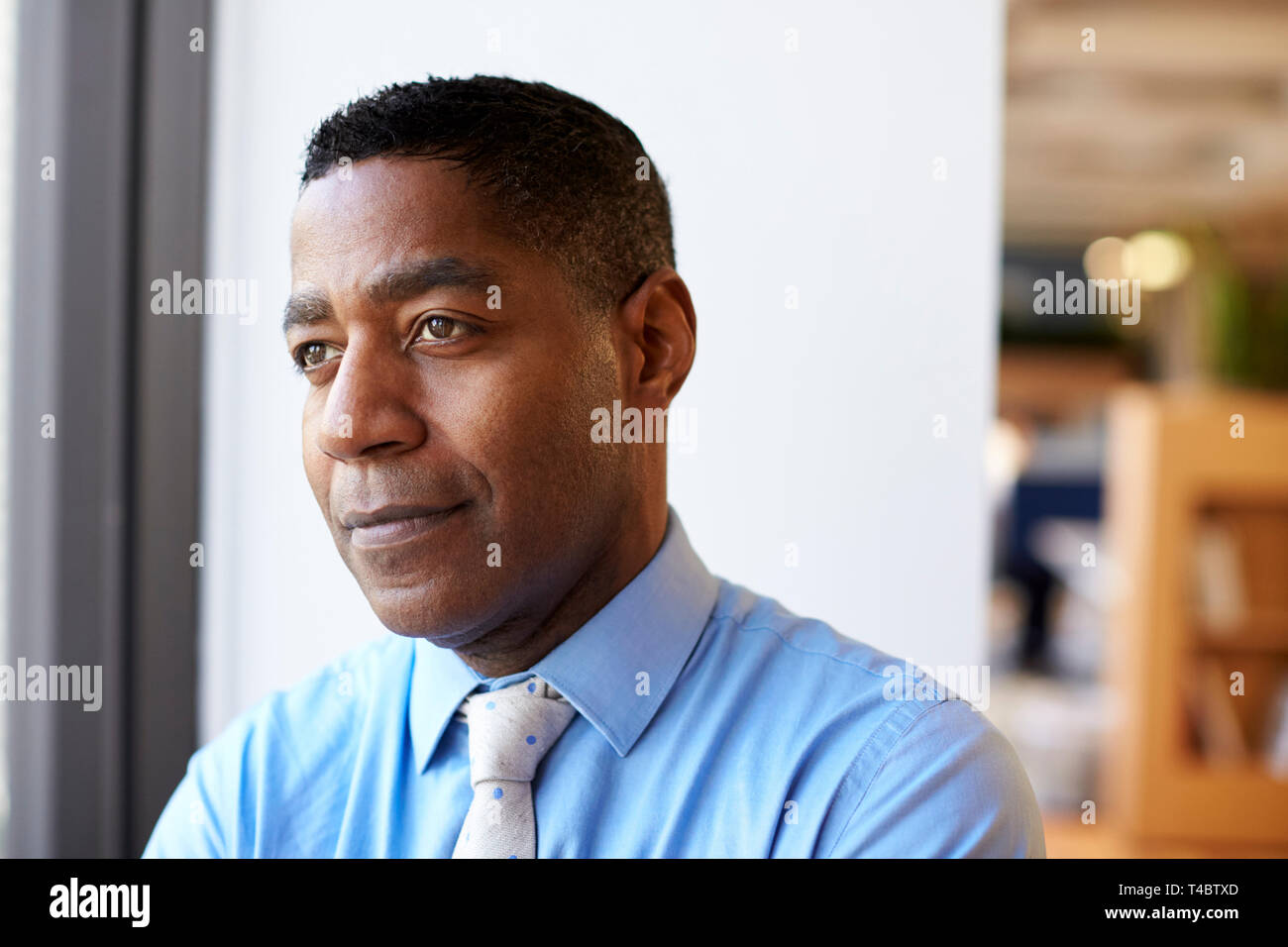 Lächelnd Reife Geschäftsmann in modernen Büro stehen, Fenster Stockfoto