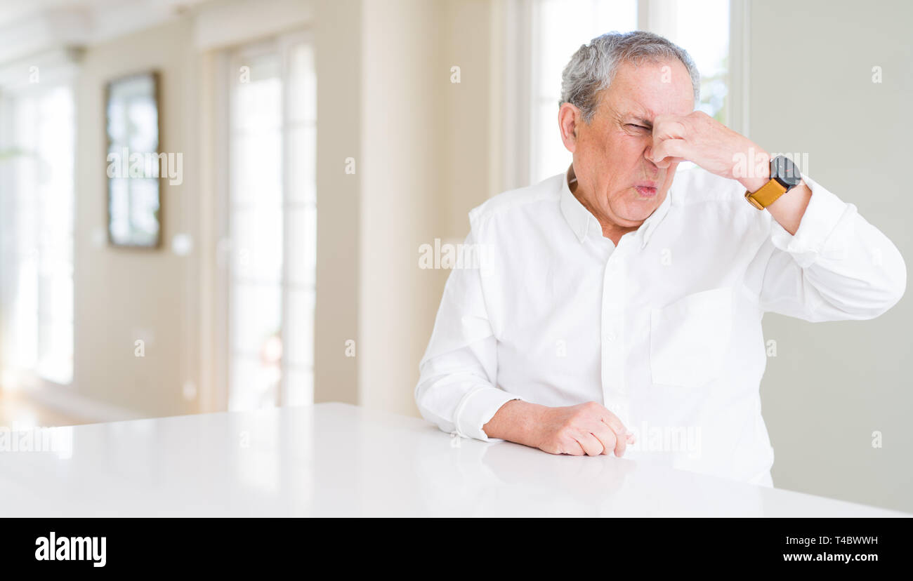 Gut aussehender älterer Menschen zu Hause riechen etwas stinkig und ekelhaft, unerträglichen Geruch, Atem wird mit dem Finger auf die Nase. Schlechte Gerüche Konzept. Stockfoto