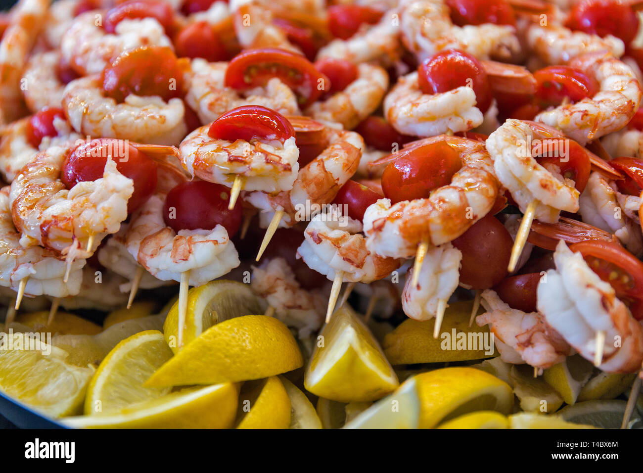 Köstliche Meeresfrüchte leckere Spieße mit Garnelen mit Tomaten, aufgereiht auf Holzstäbchen Nahaufnahme. Stockfoto