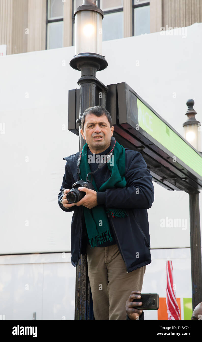 London, UK, 15. April 2019 kann ein Fotograf gewinnt ein guter Aussichtspunkt Fotos der Klimawandel Demonstranten in Oxford Circus und Regent Street, da die Demonstranten zu nehmen Londoner Straßen, indem sie menschliche Barrikaden an fünf Grenzsteine zu lähmen. Aussterben Rebellion Veranstalter Anspruch 30.000 eco-Demonstranten erwartet wichtigen Routen heute zu blockieren. Sie zogen auch ein Boot bis Regent Street die Bedrohung der globalen Erwärmung zu markieren, sondern auf eine dunklere Seite Sie Windows an Tanks Sitz zertrümmert. Credit: Keith Larby/Alamy leben Nachrichten Stockfoto