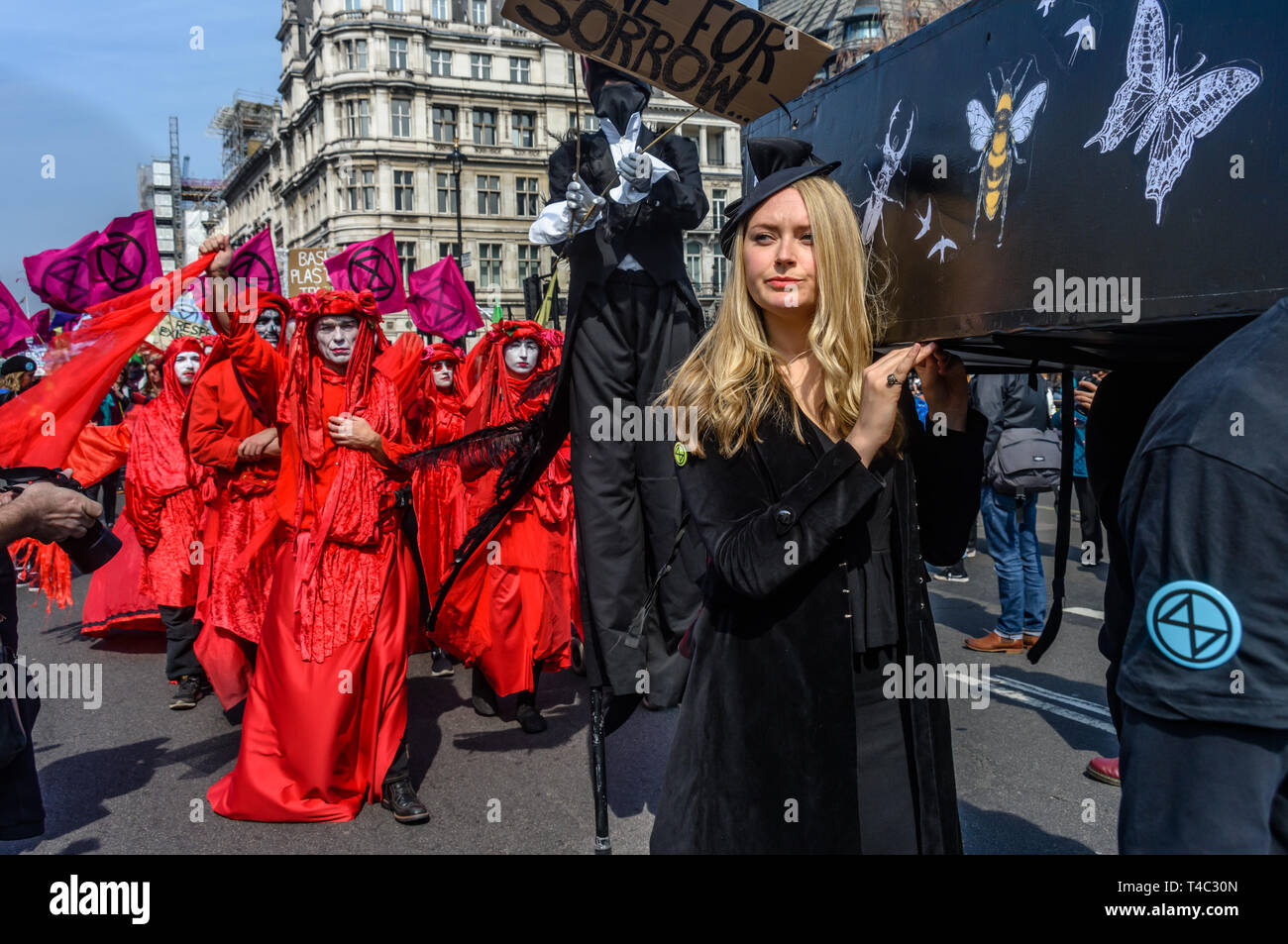 London, Großbritannien. 15. April 2019. Aussterben Rebellion New Orleans Trauerzug im Parlament Platz mit Jazz Band und Gruppen von Trauernden in Rot und andere nach der Sarg Ende n der Mitte des Platzes. Credit: Peter Marschall/Alamy leben Nachrichten Stockfoto