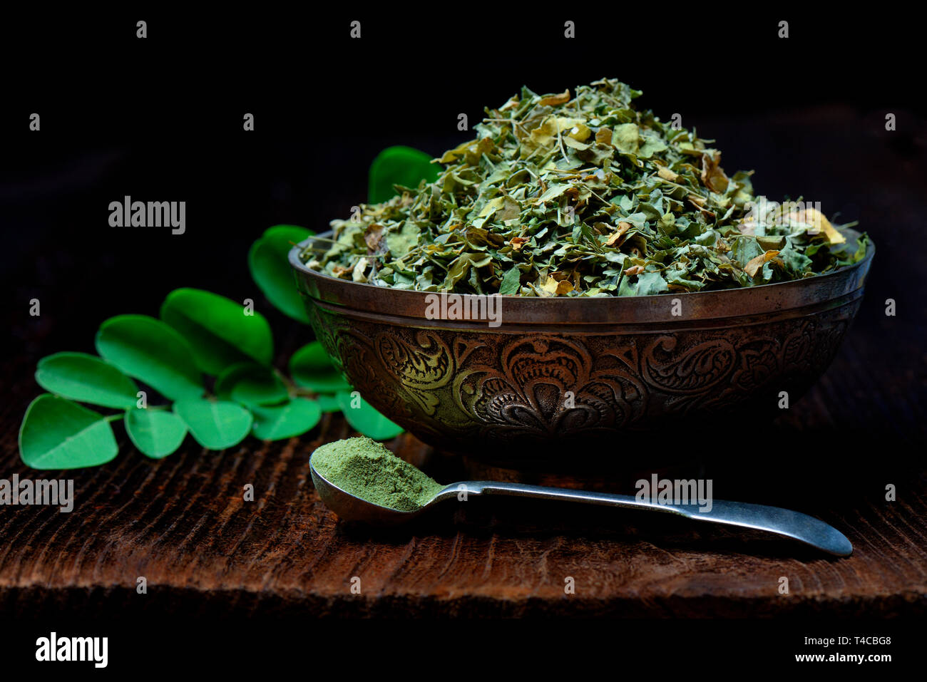 Moringa, getrocknete Moringa-Blaetter in Schale, mit Moringapulver Laeffel Stockfoto