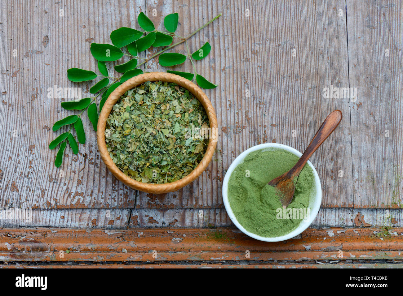 Moringa, Moringa-Pulver in Schale mit Holzloeffel, getrocknete und frische Moringablaetter, Moringapulver, Moringa oleifera Stockfoto