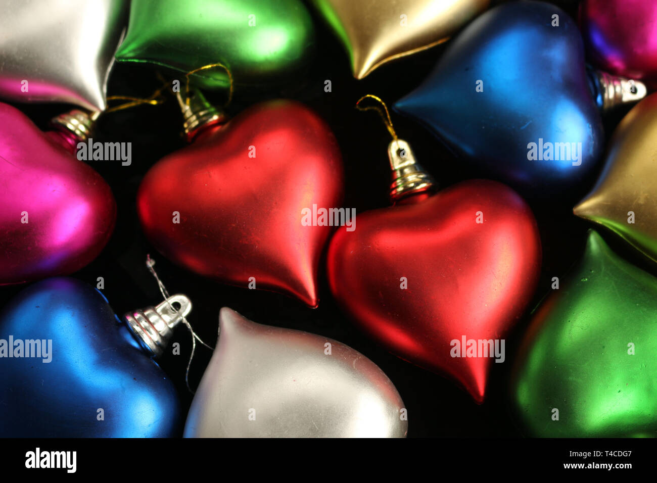 Zwei rote Herzen durch andere bunte Herzen Dekorationen Umgeben Stockfoto