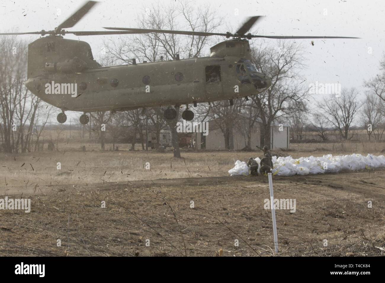 Eine Nebraska Army National Guard CH-47 Chinook Hubschrauber schwebt über Sandsäcke für sling Ladevorgänge in Nemaha, Neb., 18. März bereit. Die Nebraska National Guard ist Teil einer größeren Anstrengung auf historischen Überschwemmungen in Nebraska. (Nebraska National Guard Stockfoto