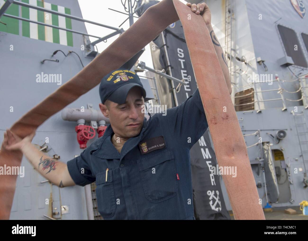 Philippinischen MEER (20. März 2019) Seaman Apprentice Brandon Bache, von Billings, Mont, Abflüsse Wasser aus einer Entwässerung Schlauch an Bord der Arleigh-Burke-Klasse geführte Anti-raketen-Zerstörer USS Curtis Wilbur (DDG54). Curtis Wilbur ist Vorwärts - in die USA 7 Flotte Bereich für Maßnahmen zur Erhöhung der Sicherheit und Stabilität in der indopazifischen Region bereitgestellt. Stockfoto