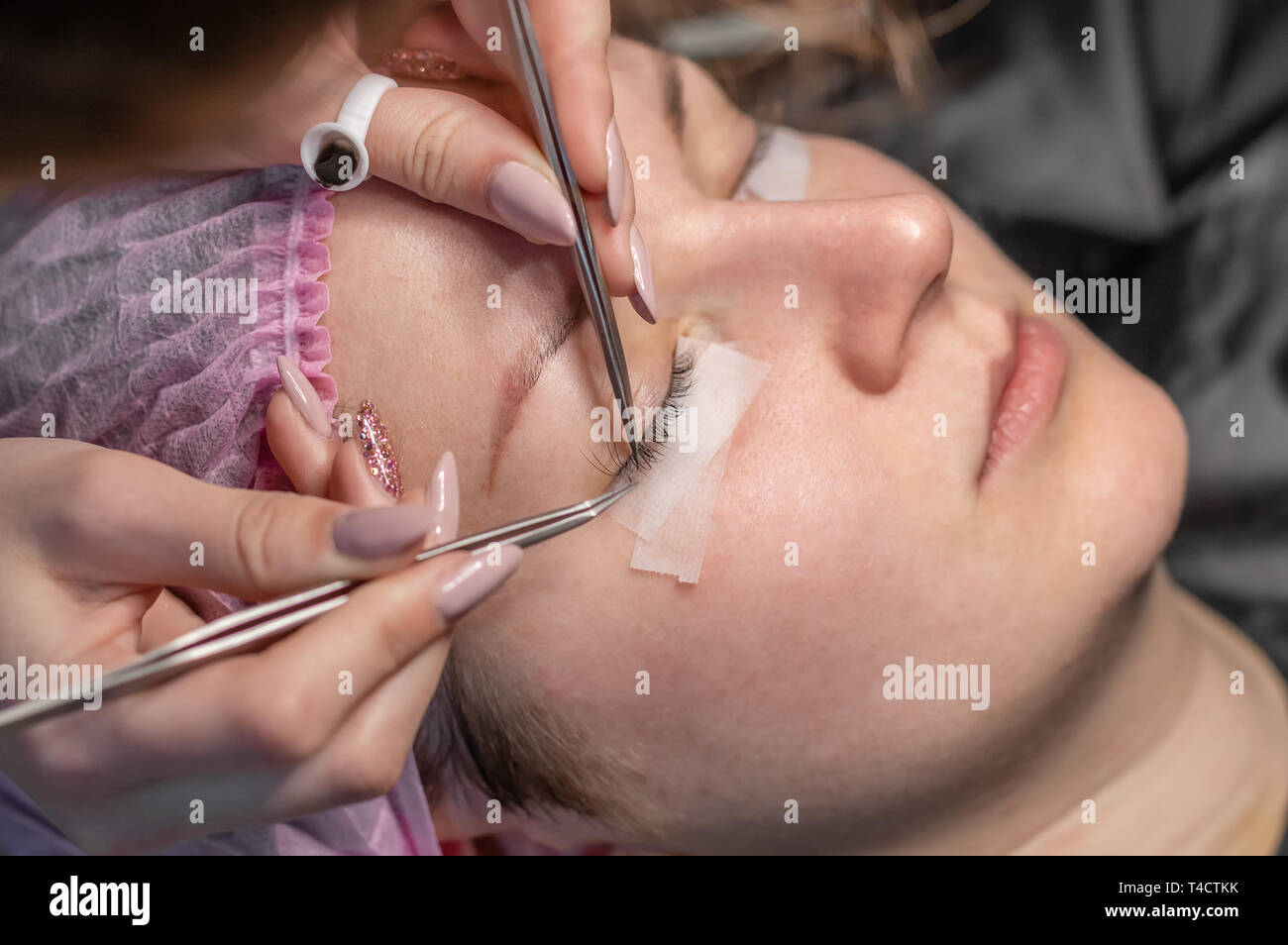 Eyelash Extension verfahren. Weibliche Augen mit langen Wimpern. Wimpern, Nahaufnahme, selektiven Fokus. Professionellen Kosmetikerin, künstliche Wimpern Stockfoto