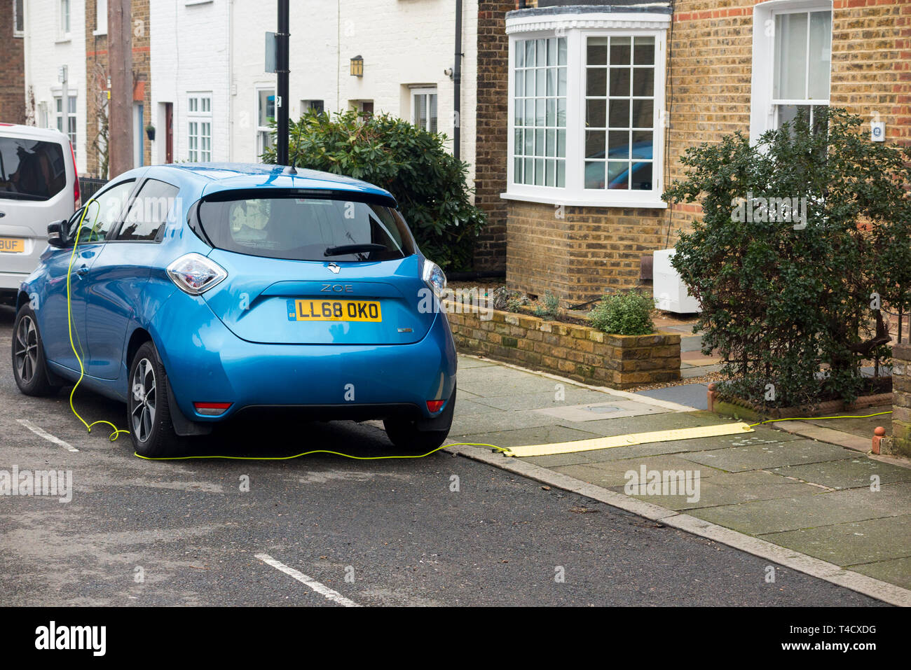 Renault Zoe elektrische Auto Fahrzeug mit Batterien aufgeladen werden, mit einem elektrischen Kabel von einem inländischen Haus. UK. (106) Stockfoto