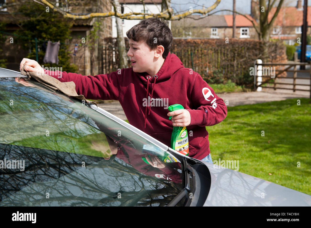 Teenager Reinigung Eltern Auto. Stockfoto