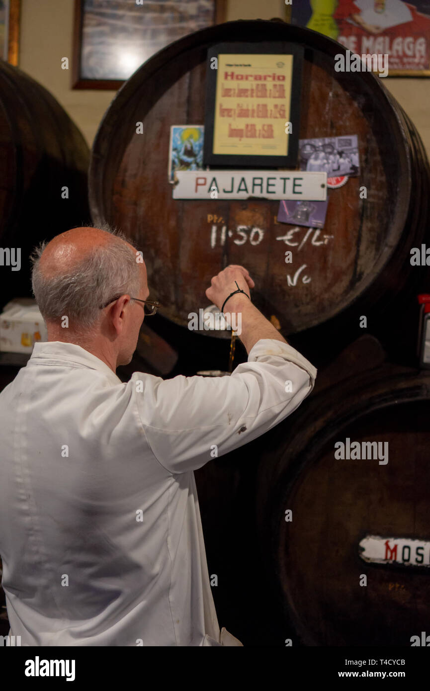 Malaga, Spanien 04.04.2019: Bar Tender gießen Sie die berühmten pajarete spanischer Wein aus Sherry Fässer in der berühmten authentischen Bodega Antigua Casa de Guardia Stockfoto