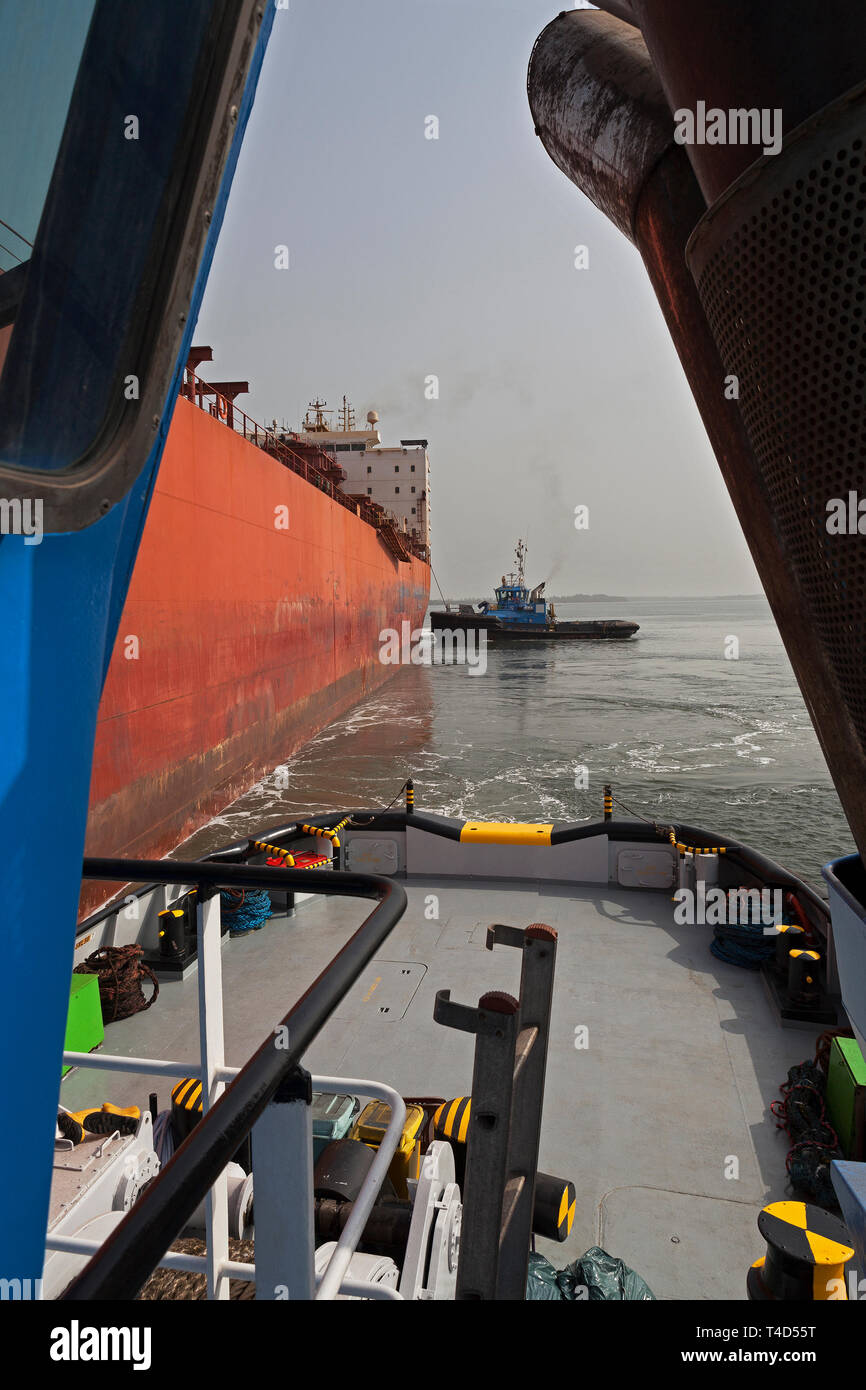 Port Operations für den Transport von Eisenerz. Führende tug von tugboat Schiff-zu-Schiff-STS Liegestelle transhipper am Lader Jetty vor Laden Stockfoto