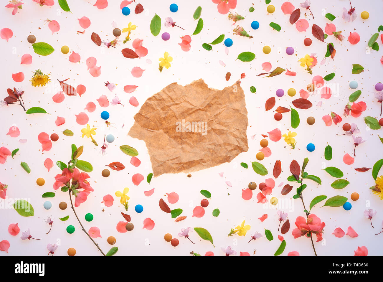 Stück zerknittertes Papier über bunten Frühling Hintergrund o Blüten und Blätter als Mock up Kopie Raum Stockfoto
