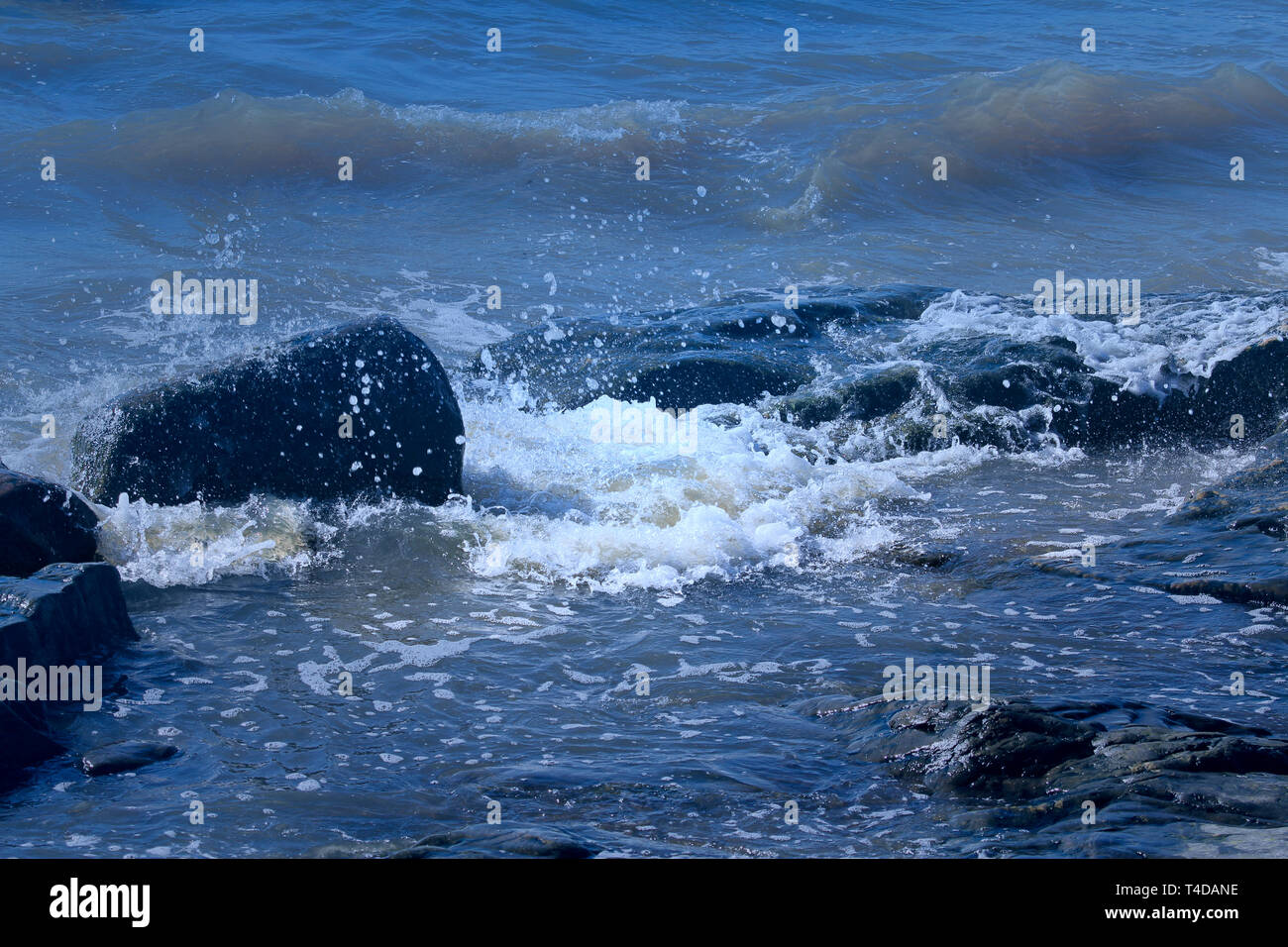 Blauen Wellen auf die Felsen an der Küste. Stockfoto