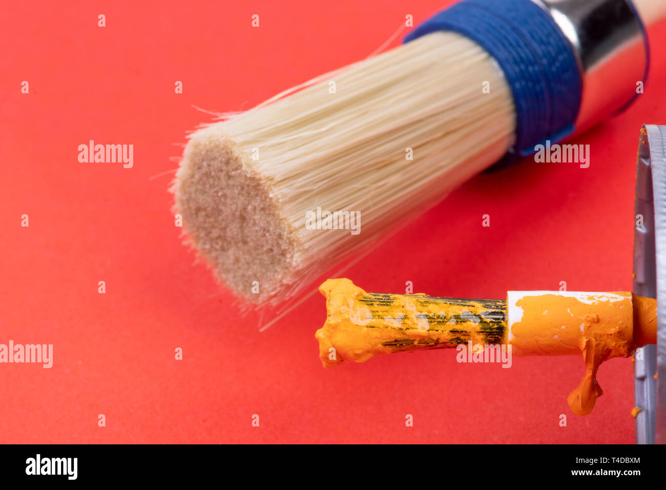 Der weiße, runde Maler Pinsel und eine kleine schwarze dekorative Pinsel mit Orange Stockfoto