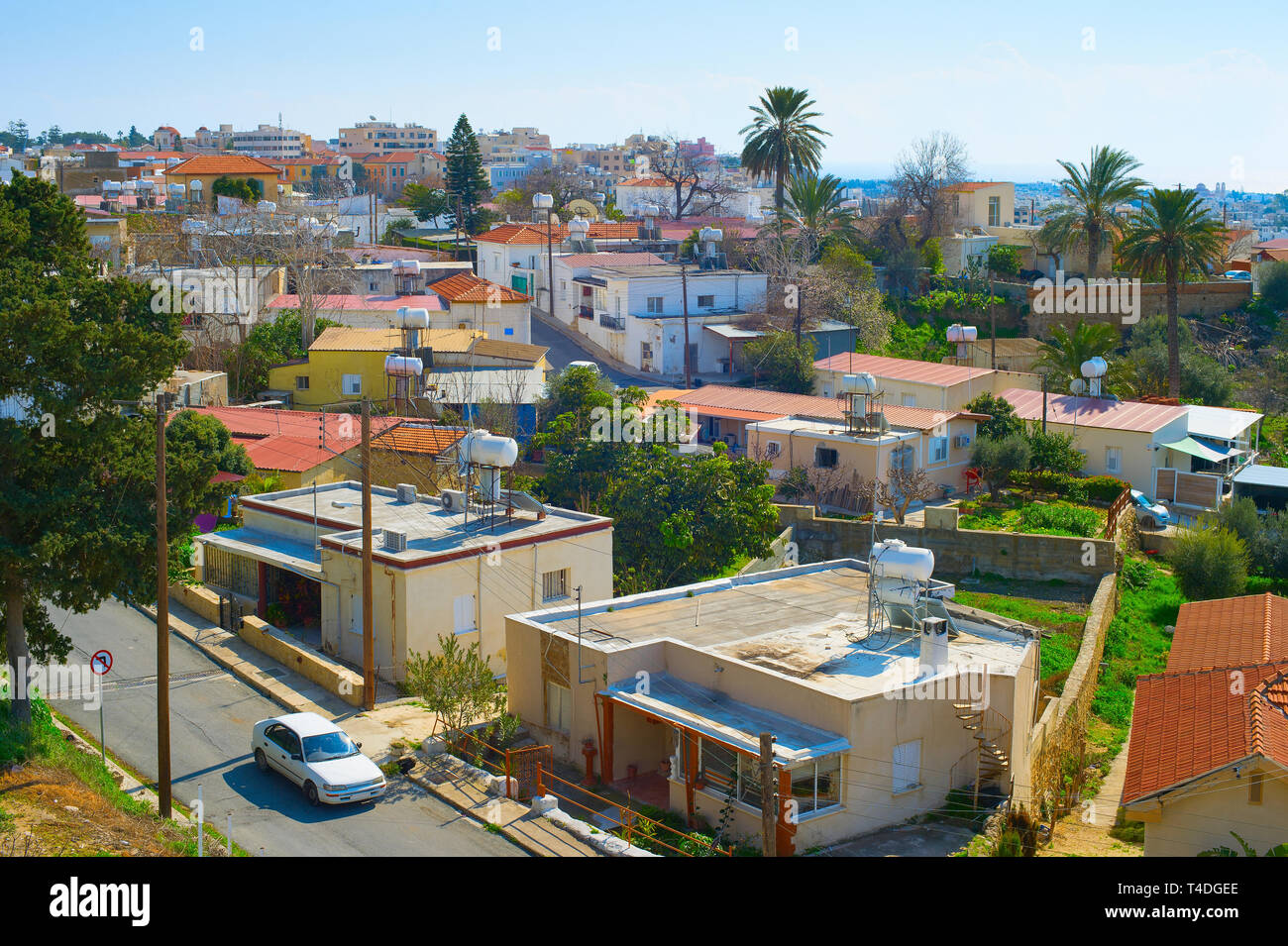 Antenne Skyline von Paphos Stadt im Sonnenlicht, Auto auf der Straße zwischen den Häusern der typischen Architektur, Palmen und grünen Bäumen, Zypern Stockfoto