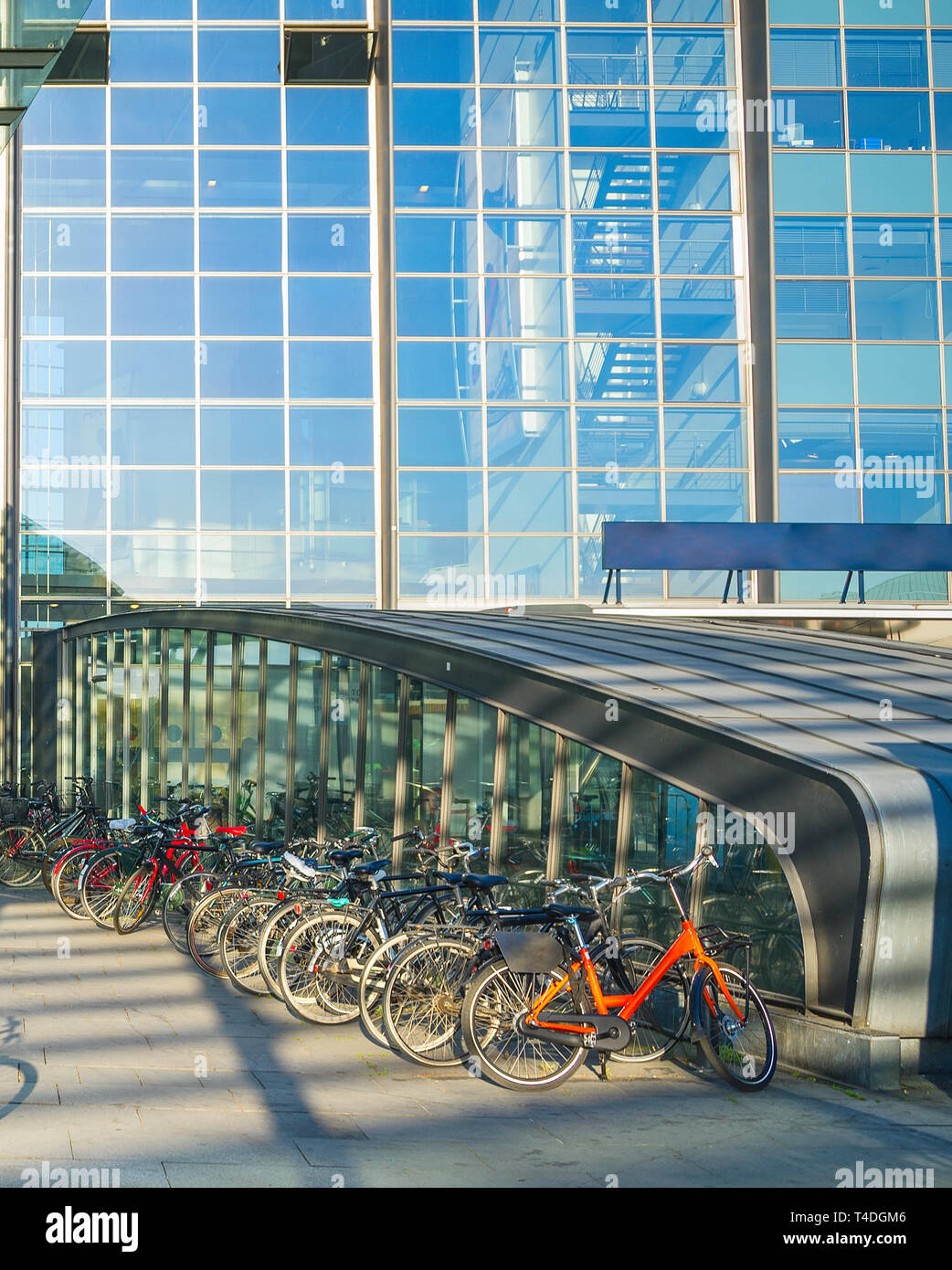 Parken von Fahrrädern durch Flughafen Kastrup Eingang unter dem Vordach, Glas fassade in der Abendsonne, Kopenhagen, Dänemark Stockfoto