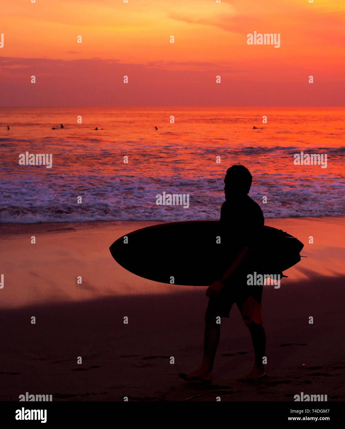 Surfer mit Surfbrett zu Fuß durch die Ocean Beach. Die Insel Bali, Indonesien Stockfoto