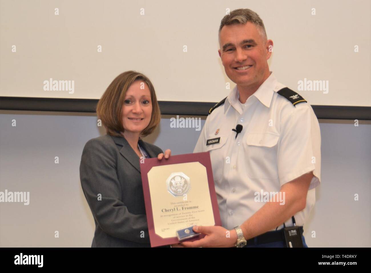 Cheryl Fromme, eine AMERIKANISCHE Armee Korps von Ingenieuren Norfolk Bezirk Mitarbeiter, hält eine Auszeichnung von Norfolk Bezirk Kommandant Oberst Patrick Löser während der Bezirk - breite Rathaus Sitzung am Fort Norfolk, Virginia, 21. März 2019 präsentiert. Bei der Veranstaltung, stellte seine dauerhafte Prioritäten: Kümmern, arbeiten in einer Weise, die zukünftigen Geschäftsabschlüsse und Möglichkeiten ausschöpfen zu ändern. Stockfoto