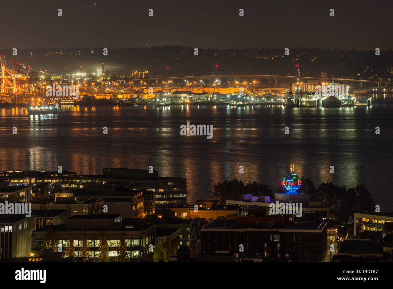 Orange Lichter iluminate der Hafen von Seattle und Elliott Bay bei Nacht. Stockfoto