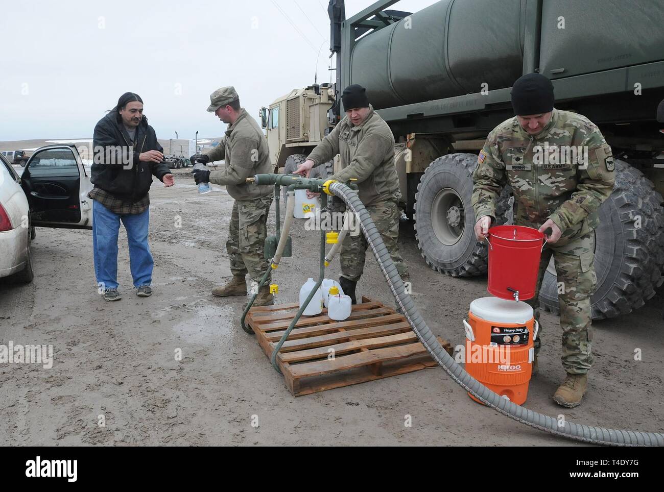 Von links) South Dakota Army National Guard Soldaten SPC. Tracy Lennick, Sgt. David Fuegen und Oberstleutnant Lew Weber füllen Sie Behälter mit Trinkwasser für die Bewohner von Kleie Ecke auf der Pine Ridge Reservation, S.D., 25. März 2019. 13 SDARNG Soldaten mit Firma A, 139 Brigade Support Bataillons, wurden für die Aufgabe des Staates in Pine Ridge aktiviert nach einer Grafschaft Grenzlinie aufgrund der extremen Hochwasser Bewohner verlassen in sieben Gemeinden ohne Wasser in ihren Häusern ist fehlgeschlagen. Stockfoto