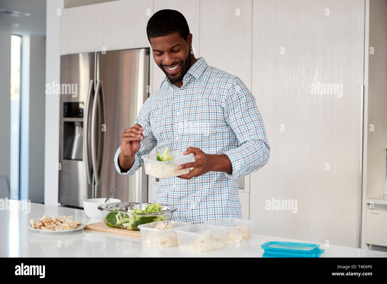 Mann in der Küche vorbereiten proteinreiche Mahlzeit und Teile in Kunststoffbehältern Stockfoto