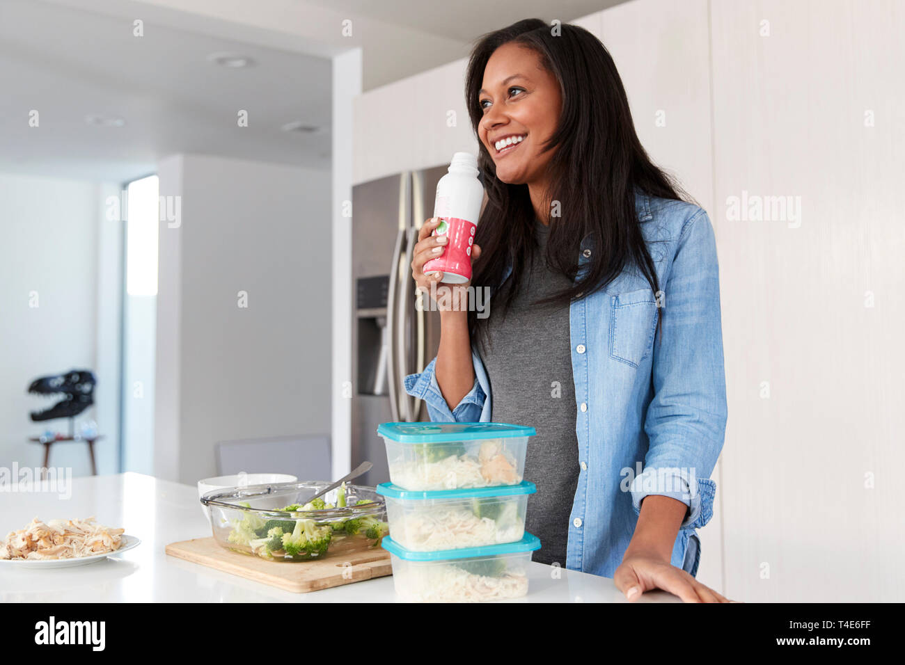 Die Frau in der Küche vorbereiten gesunde Mahlzeit aus der Flasche trinken Protein Shake Stockfoto