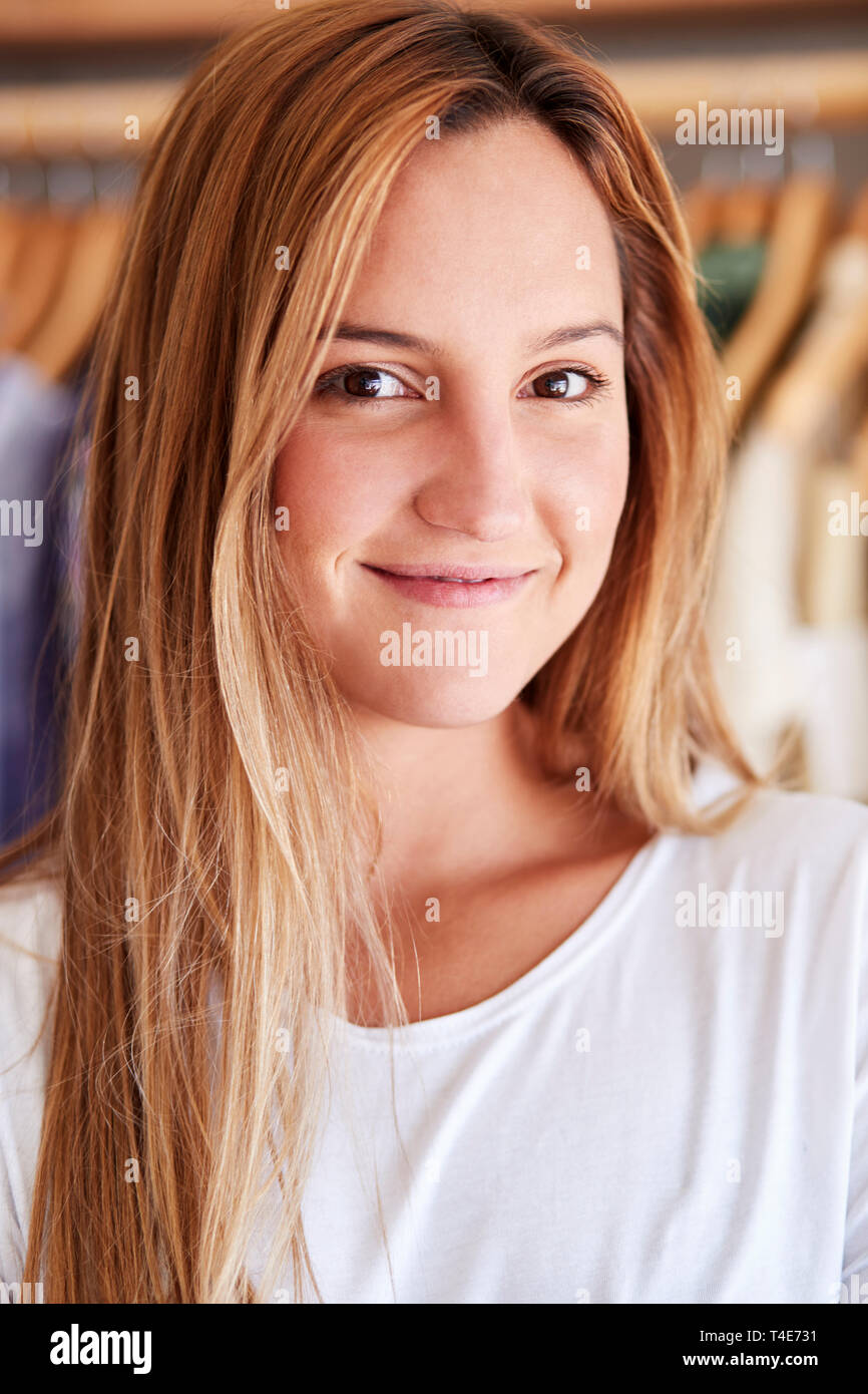 Portrait der weiblichen Kunden oder Eigentümer von Racks von Kleidung in Independent Fashion Store Stockfoto
