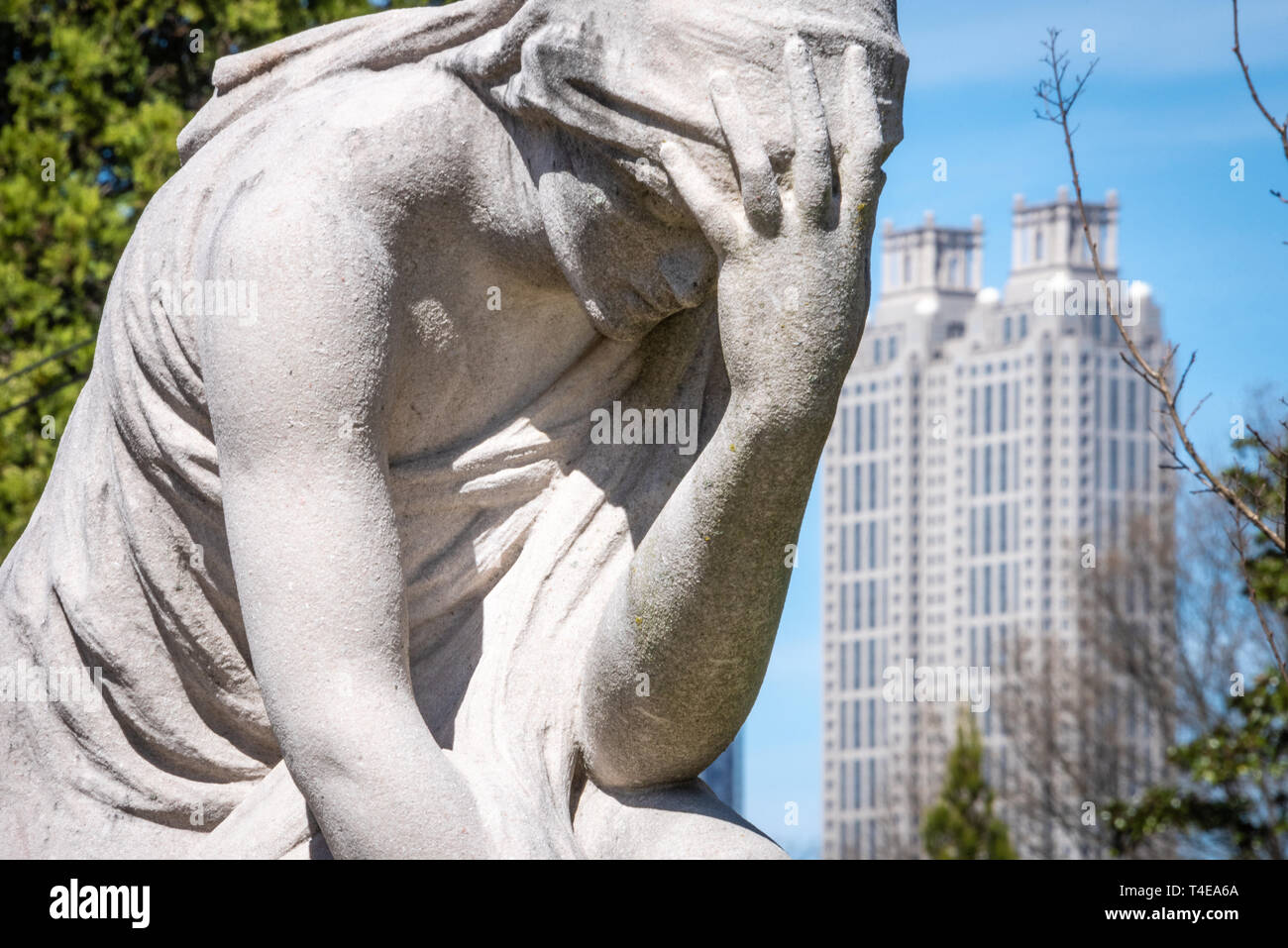 Die weinende Frau statue am grauen Menge im Historischen Friedhof mit Oakland Downtown Atlanta, 191 Georgia Peachtree Tower im Hintergrund. (USA) Stockfoto