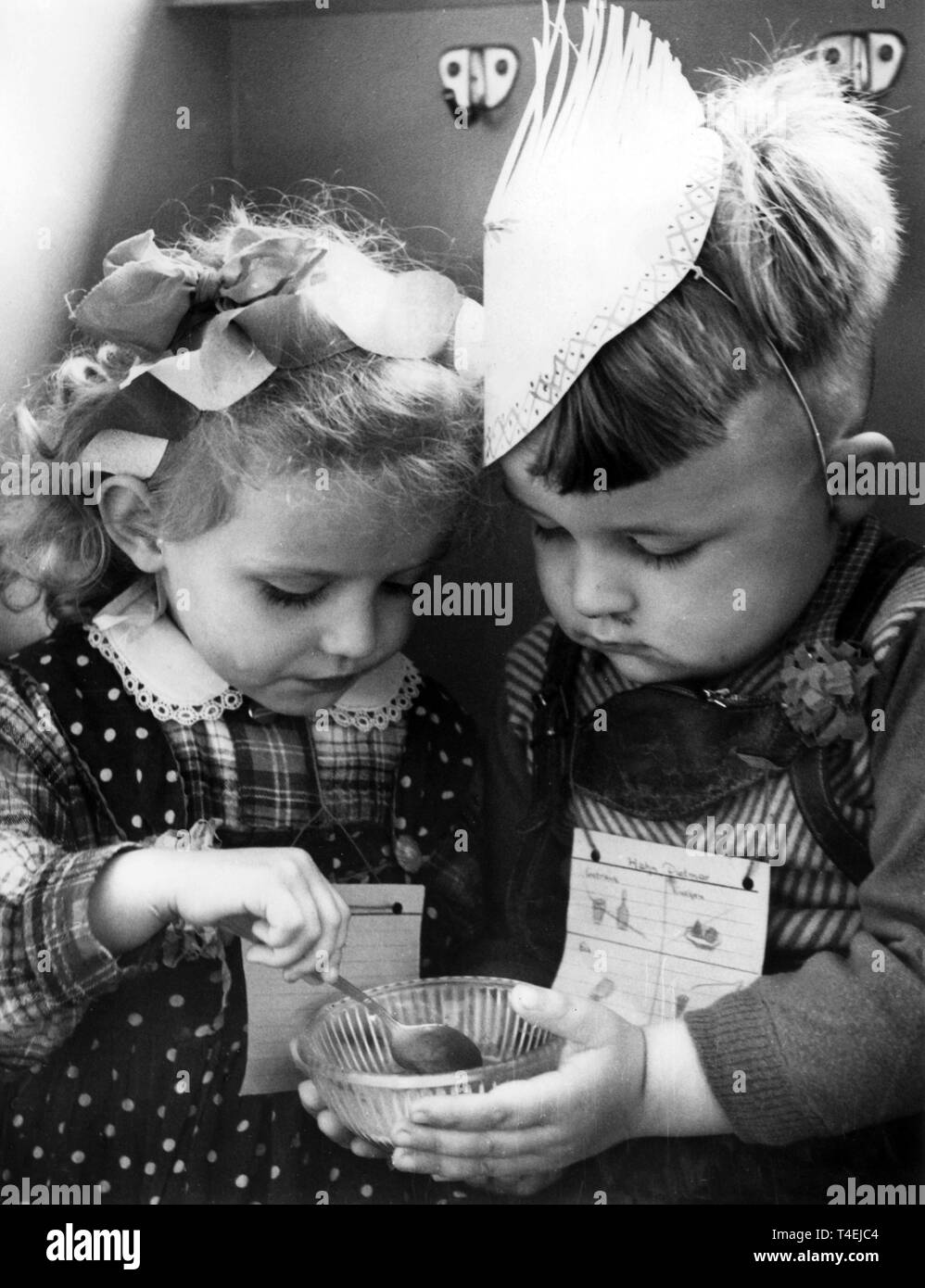 Im Kindergarten Weidenweg im Berliner Stadtbezirk Friedrichshain essen zwei Kinder gemeinsam ein Schüsselchen Eis. Ganz der Kavalier, hält der Junge das Schüsselchen für seine kleine Freundin. (Aufnahme vom 01.06.1960) | Verwendung weltweit Stockfoto