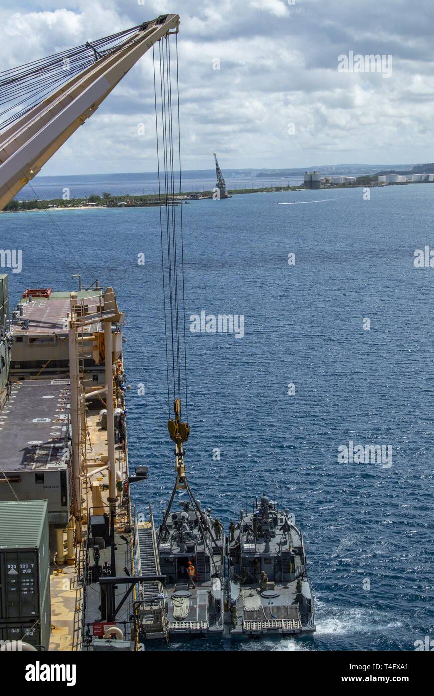 SANTA Rita, Guam (4. April 2019) Segler an die in den Küstenzonen Riverine Squadron 2 Det zugeordnet. Guam und Marine Cargo Handling Bataillon (NCHB) 1, Det. Guam bereiten ein Mark VI patrol Boot während eines Proof of Concept lift Betrieb neben dem Militärischen Sealift Command maritime Vorpositionierung Kraft ship USNS 2nd Lieutenant John S. Bobo (T-AK 3008) in Apra Harbor zu heben. NCHB-1, Loslösung Guam, Commander, Task Force 75 zugeordnet, ist nur aktiven Dienst in der Marine cargo handling Bataillon. NCHB-1, Loslösung Guam, Commander, Task Force 75 zugeordnet, ist nur aktiven Dienst in der Marine cargo handling Bataillon. Sie ar Stockfoto