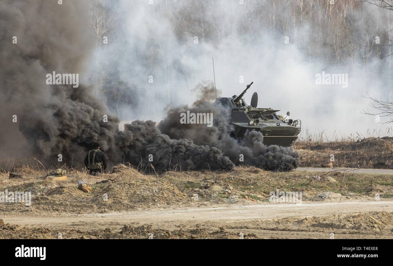 Ein BTR bewegt sich durch den Rauch während einer Demonstration von der 72nd mechanisierte Brigade an der Yavoriv Combat Training Center, Ukraine, 5. April durchgeführt. Stockfoto