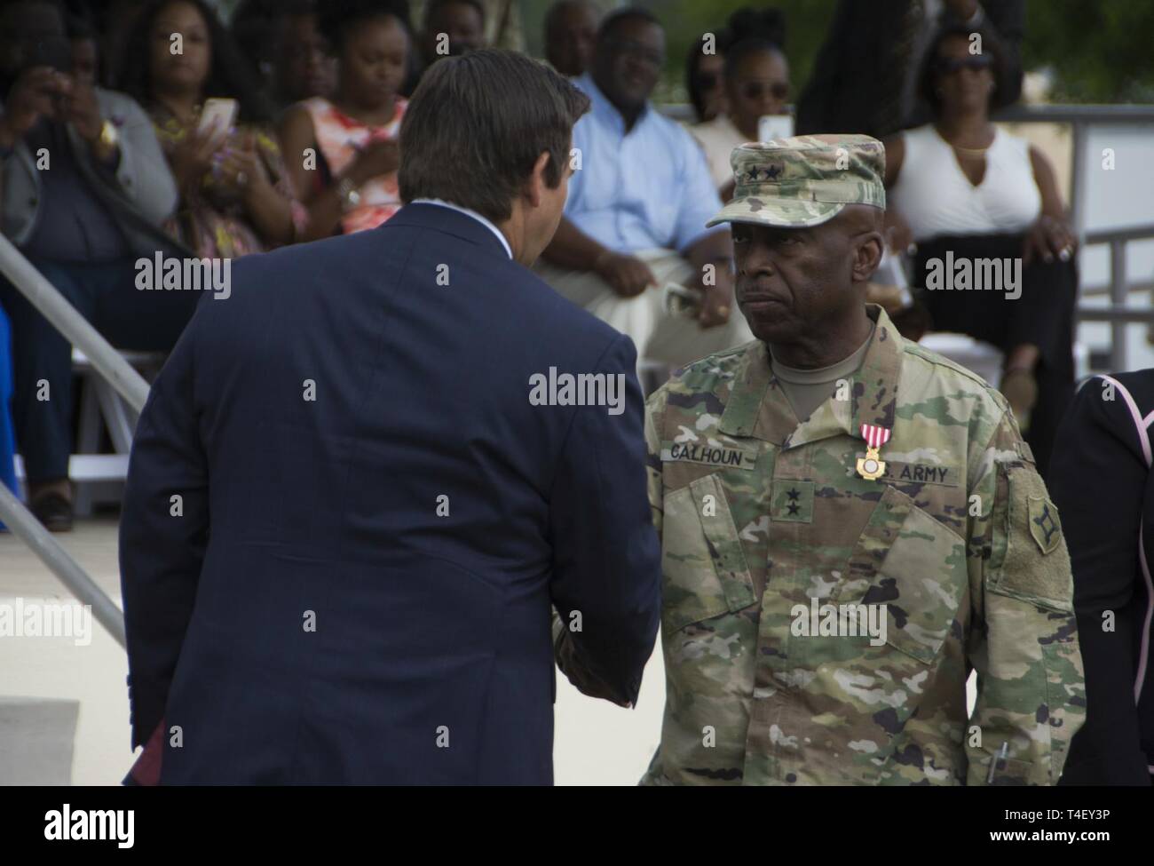 Reg. Ron DeSantis, Oberbefehlshaber der Florida National Guard, präsentiert die die Florida Kreuz Generalmajor Michael Calhoun, ausgehende Adjutant General von Florida, die während eines Befehls Zeremonie im Camp Blanding gemeinsame Training Center am 6. April. Calhoun verdient die Auszeichnung für besonders verdienstvollen Service während seiner Amtszeit als Adjutant General. Stockfoto