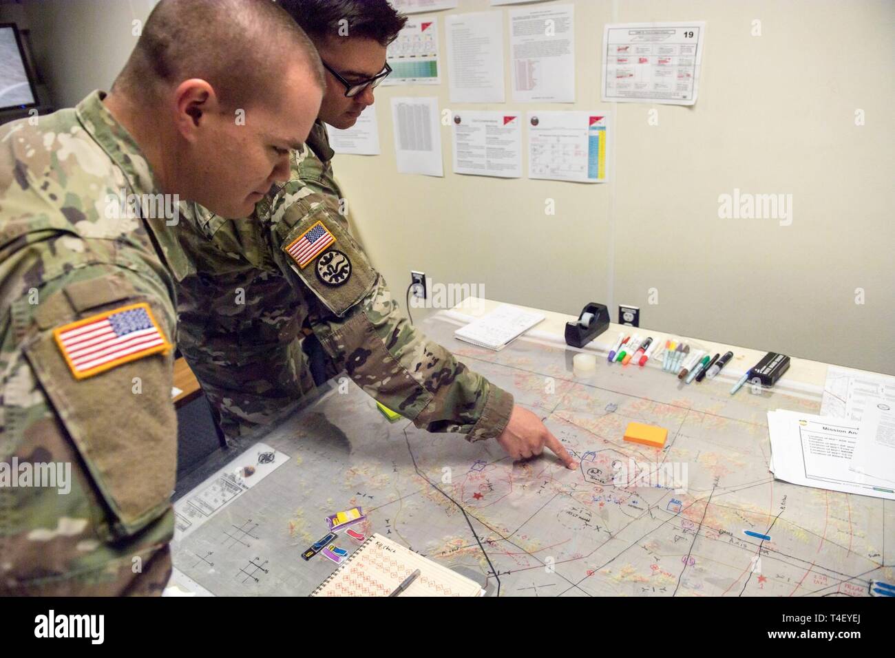 Idaho Army National Guard Kapitän James Dorman, Operations Officer, bespricht das Bataillon Betrieb Um mit 1 Lt Jeff Dahl, Hauptsitz und Sitz der Gesellschaft, 7. April 2019, an gowen Field. Die Schulung bot das Bataillon die Möglichkeit einer simulierten Bataillon Verletzung durch einen Feind Hindernis Riemen mit Hilfe der M1A2 Abrams Kampfpanzer zu leiten, Bradley Kampffahrzeugen und HMMWVs. Über die Simulatoren maximiert die Einarbeitungszeit und ermöglicht es, die auf die Mission in einer kontrollierten Umgebung üben. Stockfoto