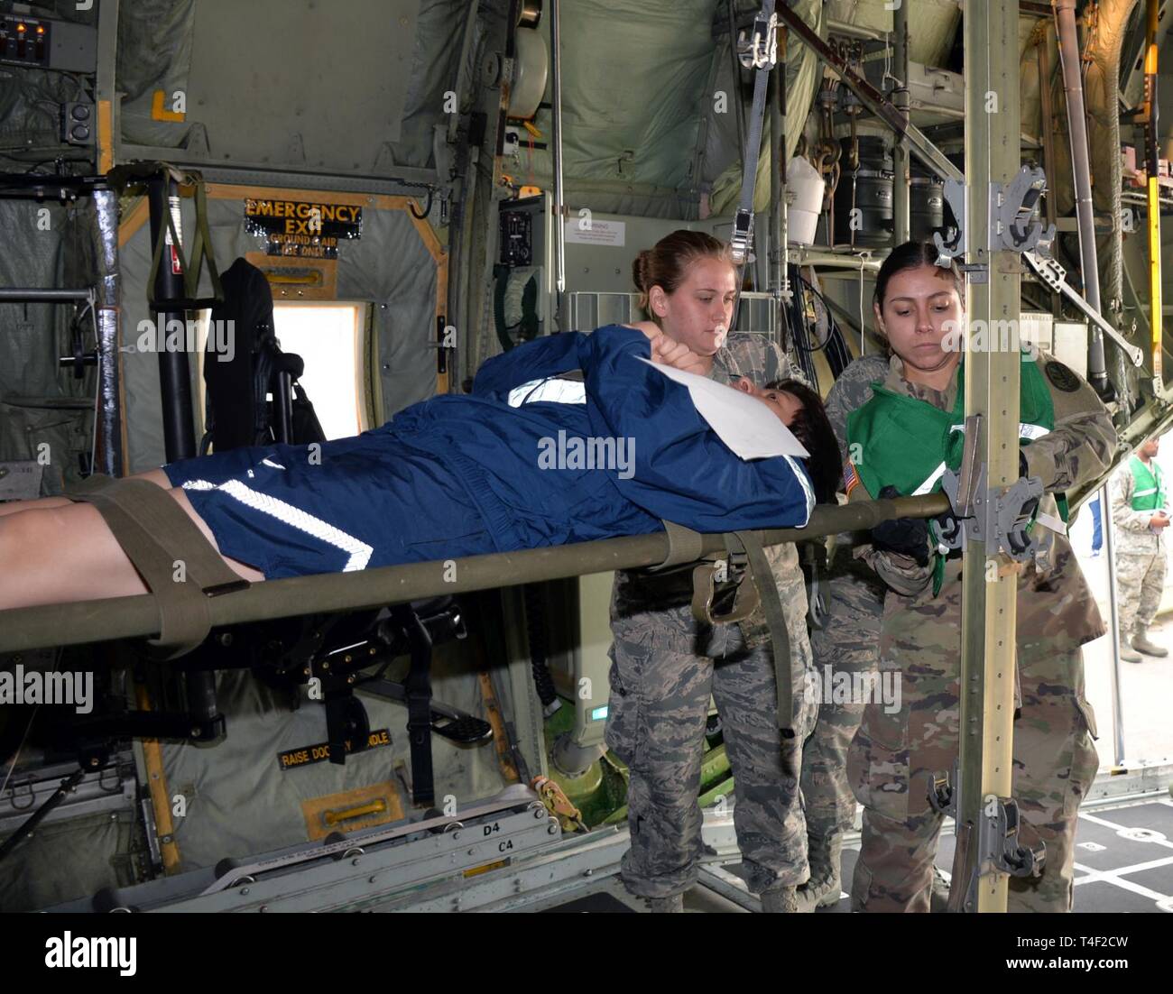 Senior Airman Amanda Geffert, 433Rd Aeromedical Evacuation Squadron Flug medic und Armee SPC. BAMC Maryssa Alfonso, Alpha Company Last eine simulierte Wurf Patienten in eine C-130H Hercules Flugzeuge für den Luftverkehr auf Joint Base San Antonio-Lackland, Texas, 20. März 2019. Verschiedene militärische und zivile Organisationen in eine nationale Katastrophe medizinische System Übung hier teilgenommen. Stockfoto