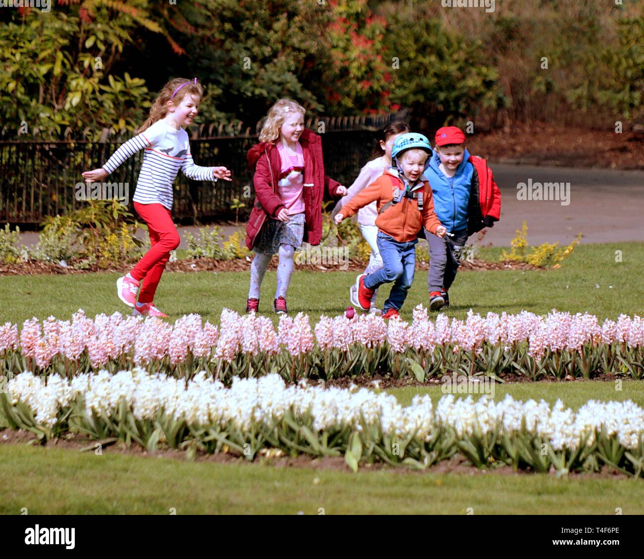 Glasgow, Schottland, Großbritannien. 11 Apr, 2019. UK Wetter: Sonnig Sommertag im Victoria Park als Grünfläche Blume der Stadt zeigt, wie Kinder spielen Stockfoto