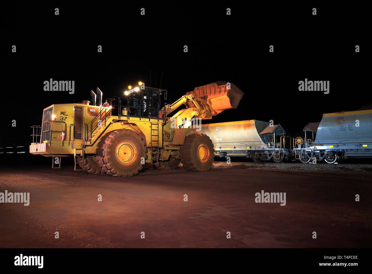 Rail Leiter Operations bei mir mit neuen Wagen auf dem Zug mit Hämatit Eisenerz bestand in der Nacht geladen wird, bevor Sie nach Port für den Verkauf im Ausland Stockfoto
