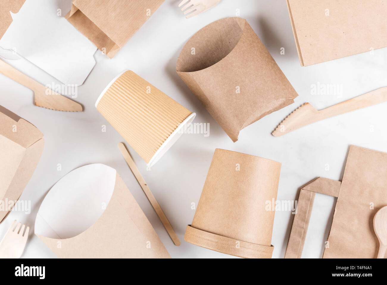 Der umweltfreundliche Einweggeschirr aus Bambus Holz und Papier auf weißem Hintergrund. Drapiert, Löffel, Gabel, Messer, Platte mit Pappbechern. Stockfoto