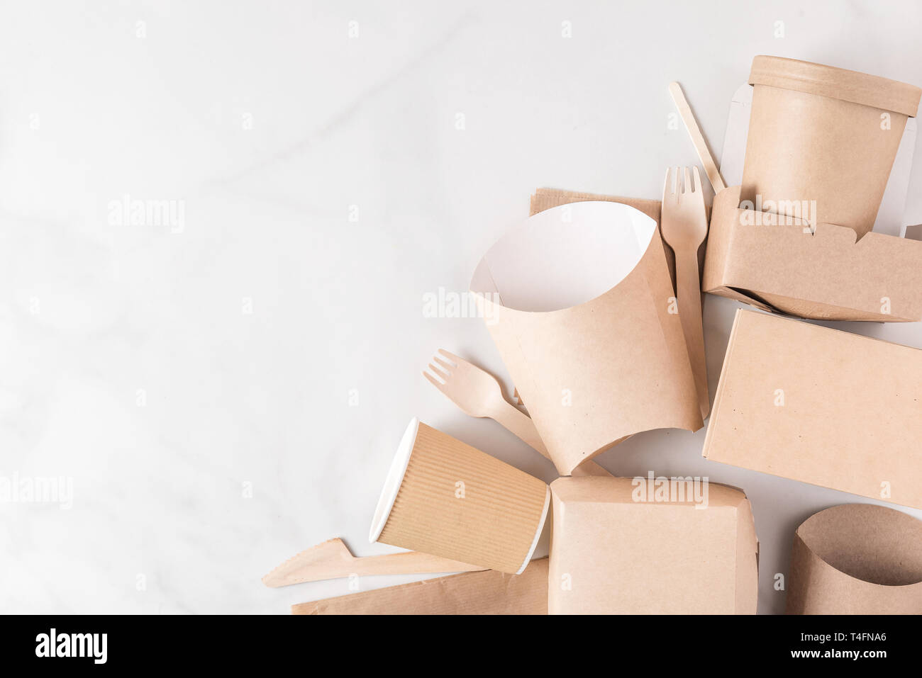 Umweltfreundliches Einweggeschirr aus Bambus Holz und Papier auf weißem Hintergrund. Drapiert, Löffel, Gabel, Messer, Platte mit Pappbechern. nach oben vi. Stockfoto