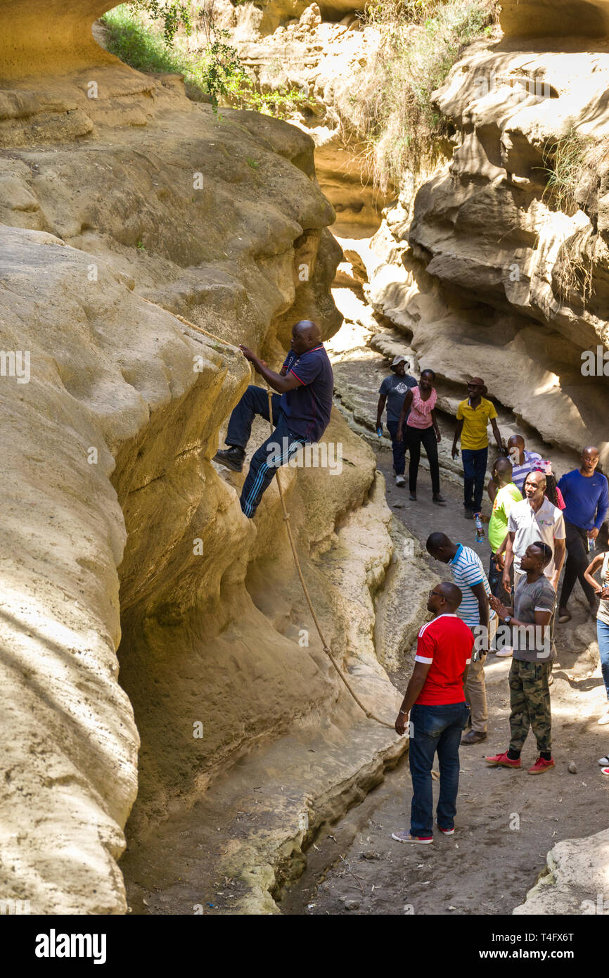 Menschen Klettern ein kurzes Seil, Ol Njorowa Gorge, Hells Gate Nationalpark, Kenia Stockfoto