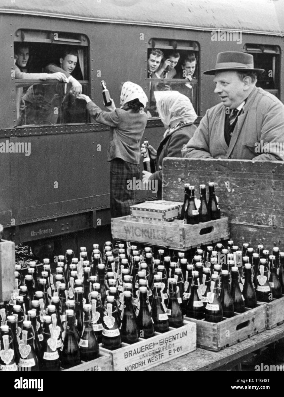 Verkäufer mit Kästen Bier zum Abschied Rekruten auf einem Bahnhof in  Düsseldorf (Nordrhein-Westfalen, Deutschland) am 4. April 1961. Es war  verboten, Alkohol auf militärischer Seite zu bringen, aber mehrere Rekruten  waren in
