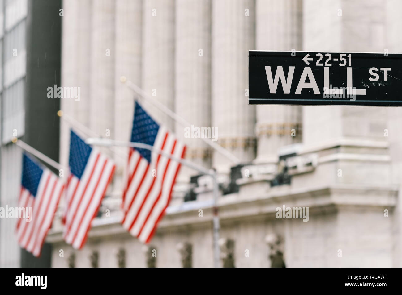 Wall Street Schild mit amerikanischen Fahnen im Hintergrund. New York city Wirtschaft Bezirk, Börse Handel und Austausch Konzept Stockfoto