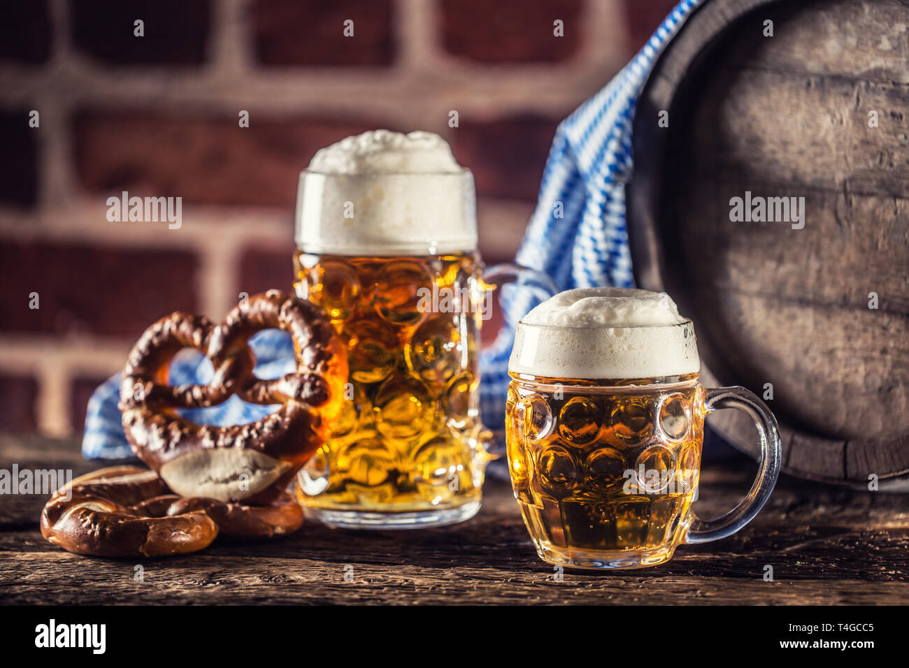 Oktoberfest große und kleine Bier mit brezel Holzfass und blau Tischdecke. Stockfoto