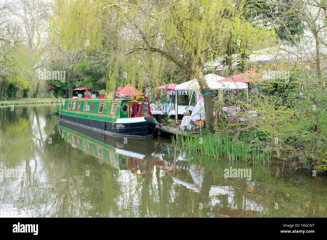 Kanal Boot neben Janes verzauberte Kaffee Garten auf der Oxford Canal an einem Frühlingsmorgen. Kirtlington, Oxfordshire, England Stockfoto