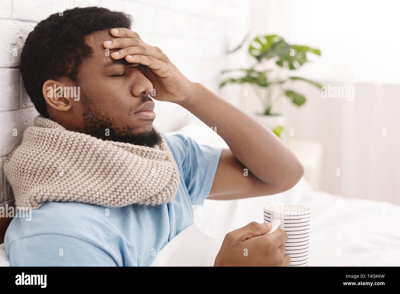 Sick african-american man die Messung der Körpertemperatur im Bett Stockfoto