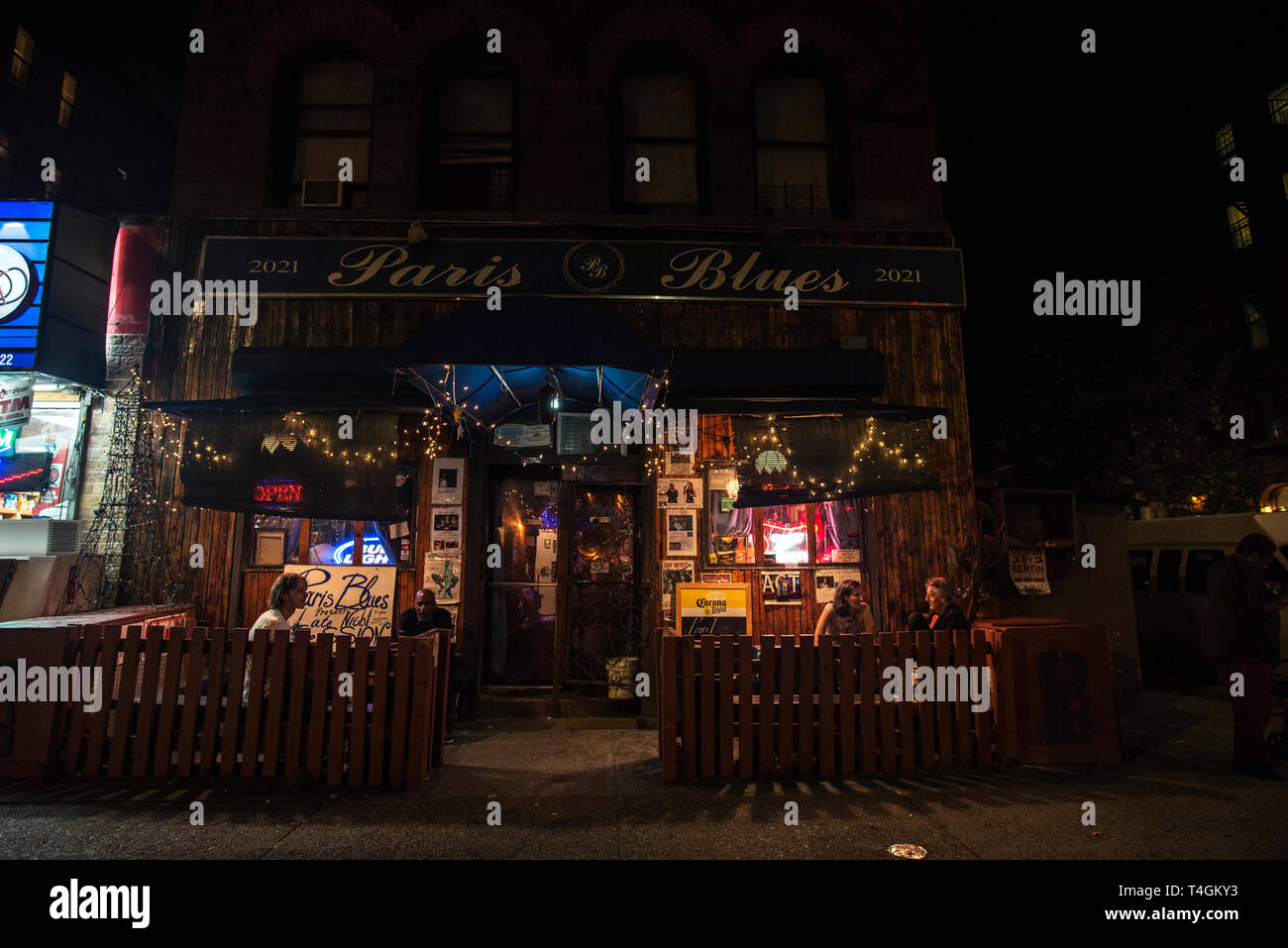 New York City, USA - 2. August 2018: die Fassade der Bar namens Paris Blues Harlem mit Menschen mit einem Drink auf der Terrasse in der Nacht in Harlem, Manhattan Stockfoto
