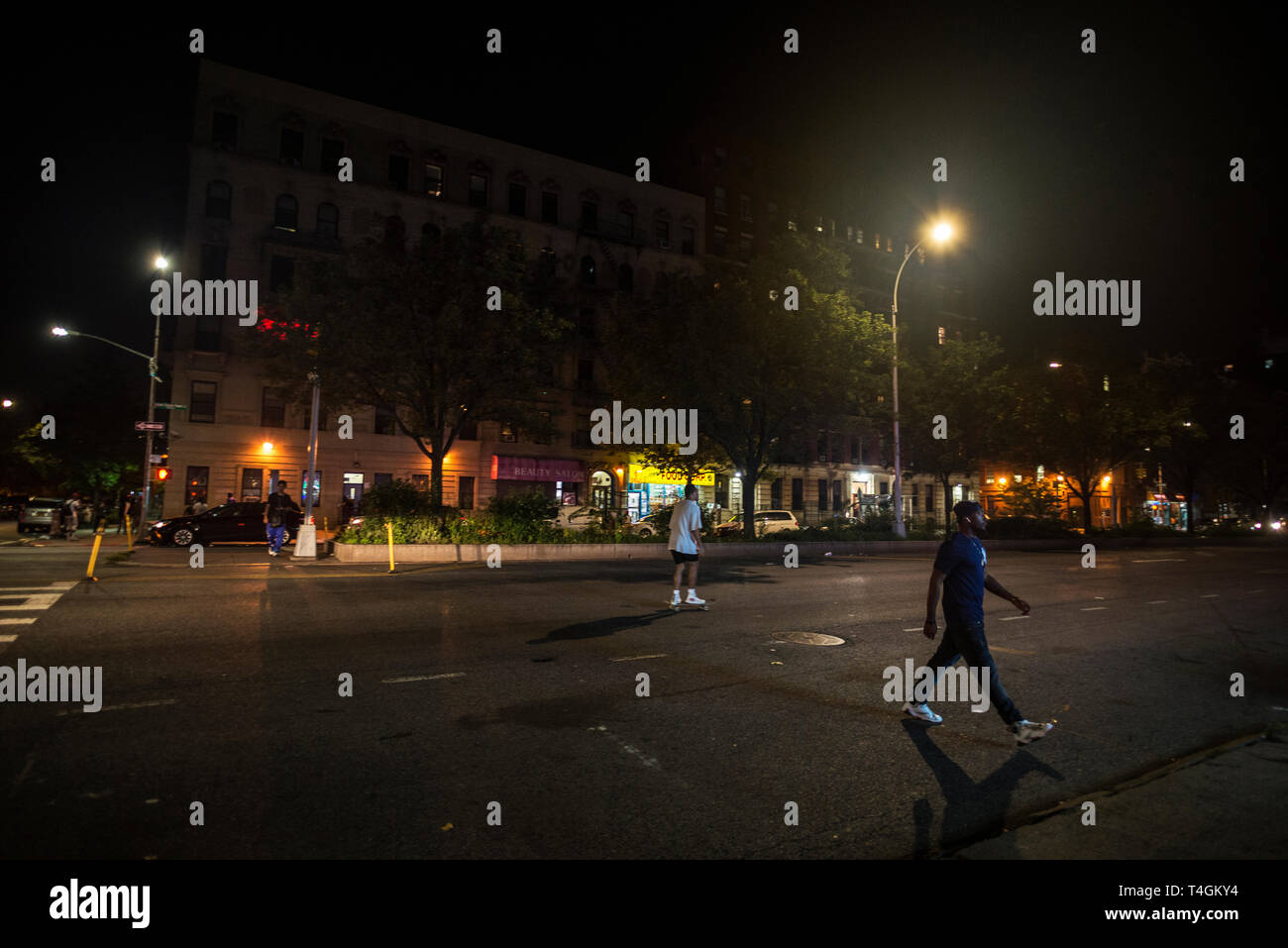 New York City, USA - 2. August 2018: die Straße mit Geschäften, Menschen zu Fuß und gehen auf ein Skateboard in der Nacht in Harlem, Manhattan, New York City, USA Stockfoto