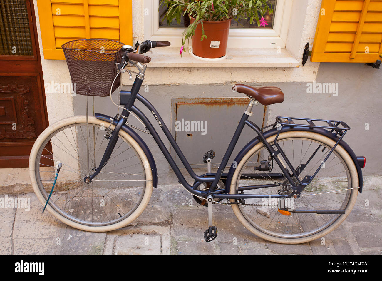Ein uriges Fahrrad durch ein Fenster geparkt Stockfoto