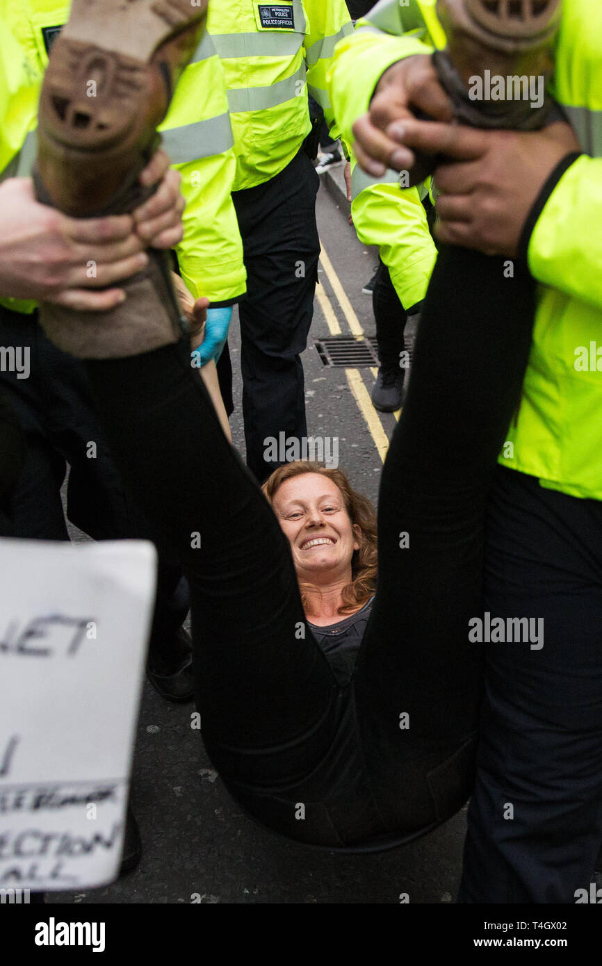 London, Großbritannien. 16. April 2019. Polizisten Anhalten ein Klima Demonstrant vor dem Aussterben Rebellion in Oxford Circus am zweiten Tag des Internationalen Stockfoto