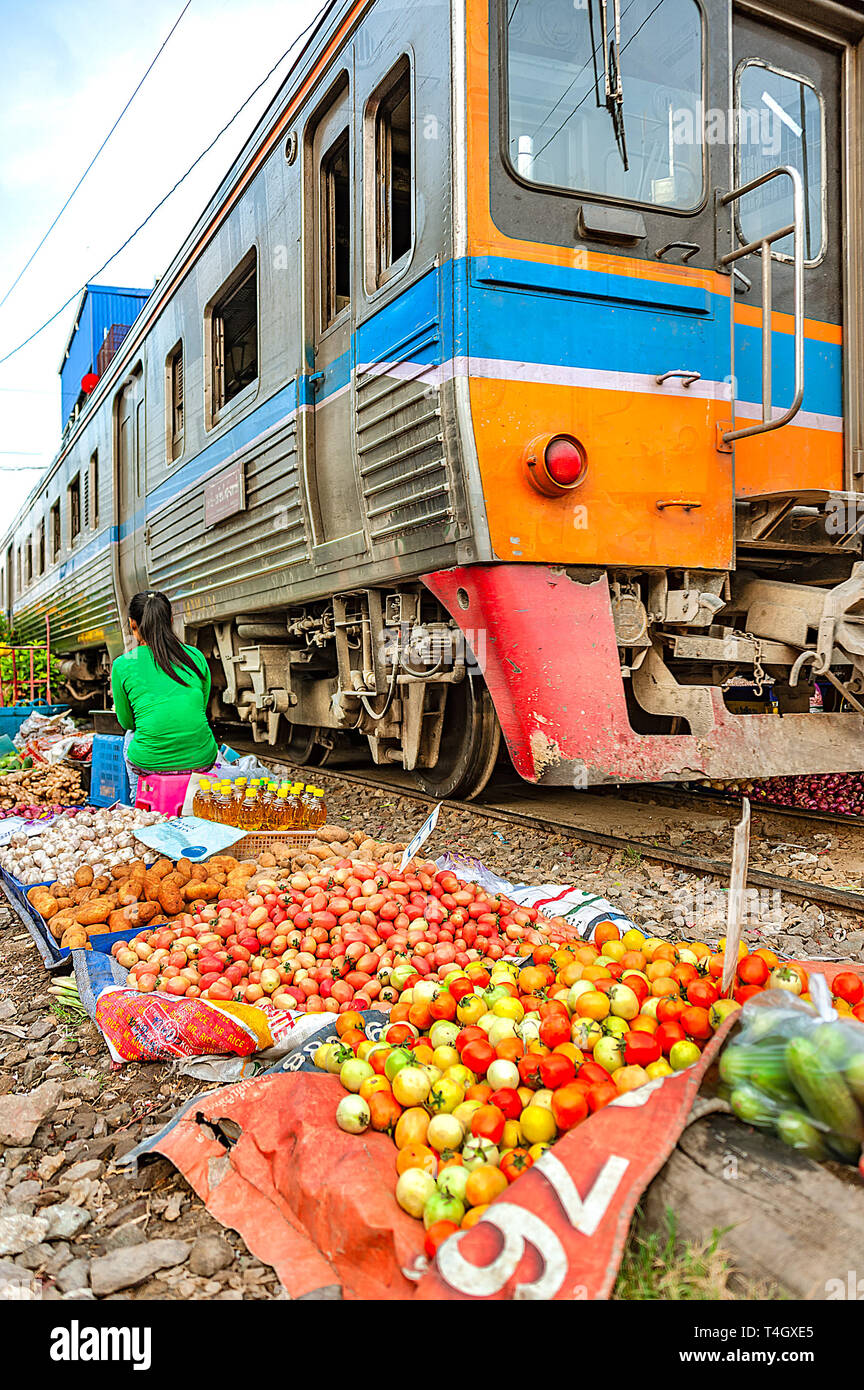 Samutsakorn Provinz, Thailand - 14. März 2019: das tägliche Leben von einem Straßenhändler verkaufen Gemüse zwischen Gleisen als gefährlich vor sich geht. Stockfoto