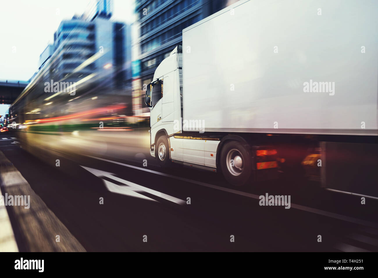 Weisse truck schnell auf dem Weg in eine moderne Stadt mit Lichteffekt Stockfoto